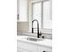 Close-up of a kitchen with modern faucet, and stainless steel sink beneath a bright window at 2340 Jamaica St, Aurora, CO 80010