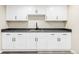 Basement wet bar featuring white cabinets, a dark countertop and dark fixtures at 2340 Jamaica St, Aurora, CO 80010