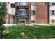 Apartment building exterior with landscaped grounds and a bike attached to the porch at 5995 W Hampden Ave # 3E, Denver, CO 80227