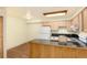 Bright kitchen features a black countertop and backsplash, wood cabinets, and modern appliances at 5995 W Hampden Ave # 3E, Denver, CO 80227