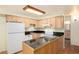 Well-lit kitchen showcasing wood cabinets, black tile countertops, and modern appliances at 5995 W Hampden Ave # 3E, Denver, CO 80227