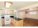 Bright kitchen featuring white appliances, a breakfast bar, and a view into the living space at 5995 W Hampden Ave # 3E, Denver, CO 80227