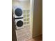 Laundry room equipped with stacked washer and dryer, as well as storage shelves at 5995 W Hampden Ave # 3E, Denver, CO 80227