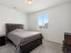 Carpeted bedroom with natural light from the windows and a dark, upholstered bed frame at 24333 E 41St Ave, Aurora, CO 80019