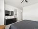 Modern bedroom with a gray quilted comforter and a black dresser beneath a wall-mounted TV at 24333 E 41St Ave, Aurora, CO 80019