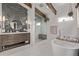 Modern bathroom featuring a soaking tub, a glass enclosed shower, and a wood vanity at 745 S Eliot St, Denver, CO 80219