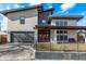 Contemporary two-story home featuring a bright red front door, a gray garage door, and a covered porch at 745 S Eliot St, Denver, CO 80219