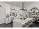 Modern white kitchen featuring stainless steel appliances, white subway tile backsplash, and a breakfast bar with seating at 745 S Eliot St, Denver, CO 80219