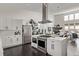 Open-concept kitchen with stainless steel appliances, modern white cabinets, and view of the dining and living spaces at 745 S Eliot St, Denver, CO 80219