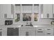 Modern kitchen featuring white cabinets, stainless steel appliances, subway tile, and a large stainless steel sink at 745 S Eliot St, Denver, CO 80219