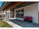 Cozy covered front porch furnished with a dark bench and red pillows at 745 S Eliot St, Denver, CO 80219