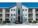 Three-story apartment building with balconies, snow-covered ground, and a clear blue sky at 12281 E Tennessee Dr # 303, Aurora, CO 80012