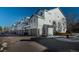 View of garage units in a row of apartments, a tree, and a clear blue sky at 12281 E Tennessee Dr # 303, Aurora, CO 80012