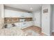 Cozy kitchen featuring white appliances and cabinetry, complemented by granite countertops and mosaic backsplash at 12281 E Tennessee Dr # 303, Aurora, CO 80012