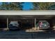 Carport with two parked cars, trash cans, and overhead lighting on a sunny day at 12281 E Tennessee Dr # 303, Aurora, CO 80012