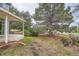 Backyard featuring a covered patio, mature trees, and wooden fence providing a private outdoor space at 897 Mockingbird Ln, Brighton, CO 80601