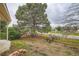 Large backyard with mature trees, wooden fence, and brick accents providing a private outdoor space at 897 Mockingbird Ln, Brighton, CO 80601