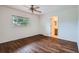 Spacious bedroom featuring a ceiling fan, wood flooring, large window, and ensuite bath at 897 Mockingbird Ln, Brighton, CO 80601