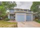 Two-story home features blue siding, beige trim, dual garages, and landscaping at 897 Mockingbird Ln, Brighton, CO 80601