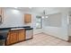 An efficient kitchen features tile flooring, oak cabinets, black countertops, and appliances at 897 Mockingbird Ln, Brighton, CO 80601