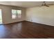 Spacious living room with hardwood floors, a ceiling fan, and a window providing ample natural light at 897 Mockingbird Ln, Brighton, CO 80601