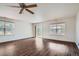 Open concept living room features hardwood floors, neutral paint, ceiling fan and windows at 897 Mockingbird Ln, Brighton, CO 80601