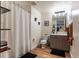 A clean bathroom with modern decor, shower with curtain, single vanity with grey cabinets, and black floor rugs at 1750 Wewatta St # 705, Denver, CO 80202