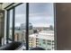 Stunning city view from a large window with comfortable seating in the foreground at 1750 Wewatta St # 705, Denver, CO 80202