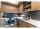 The modern kitchen features light wood cabinets, stainless steel appliances, white countertops and a dark backsplash at 1750 Wewatta St # 705, Denver, CO 80202