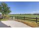 View of a fenced backyard featuring a green lawn and neighborhood houses in the distance under a clear blue sky at 1678 Wright Aly, Erie, CO 80516