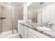 Elegant bathroom featuring granite countertops, double sinks, a shower, and white cabinetry at 1678 Wright Aly, Erie, CO 80516