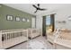 Charming Bedroom with two cribs, a patterned rug, a comfortable chair and calming green walls at 1678 Wright Aly, Erie, CO 80516