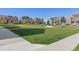 View of a common area with houses, grass, sidewalks, a pergola, trees and benches under a clear blue sky at 1678 Wright Aly, Erie, CO 80516