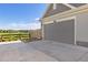 View of the two-car garage and driveway with a glimpse of the community common area in the background at 1678 Wright Aly, Erie, CO 80516