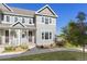 Charming gray townhome featuring a cozy front porch and lush green lawn at 1678 Wright Aly, Erie, CO 80516