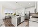 Open concept kitchen with granite island, stainless appliances, and adjacent dining area at 1678 Wright Aly, Erie, CO 80516
