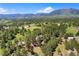 Expansive aerial view capturing the home surrounded by lush forest and mountain views at 17015 Oxbridge Rd, Monument, CO 80132