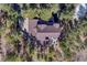 Aerial view of the home showcasing a well-maintained roof, expansive deck, and surrounding trees at 17015 Oxbridge Rd, Monument, CO 80132