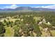 Scenic aerial view showcasing the property and its surrounding mountain and green landscape at 17015 Oxbridge Rd, Monument, CO 80132