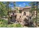 Spacious backyard featuring a deck, stone fireplace, and well-manicured landscaping at 17015 Oxbridge Rd, Monument, CO 80132
