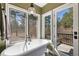 Serene bathroom with a freestanding soaking tub, scenic outdoor views, and a private deck at 17015 Oxbridge Rd, Monument, CO 80132