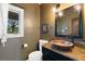 Charming powder room with a unique copper sink and granite countertops at 17015 Oxbridge Rd, Monument, CO 80132