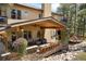 An outdoor covered patio features stone accents, wood ceilings, and comfortable seating for entertaining at 17015 Oxbridge Rd, Monument, CO 80132
