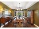 Formal dining room with dark wood furniture, ambient lighting, and a large window offers a refined entertaining space at 17015 Oxbridge Rd, Monument, CO 80132