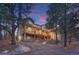 Stately multi-story home featuring an expansive wrap-around balcony and an illuminated driveway at 17015 Oxbridge Rd, Monument, CO 80132