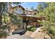 Charming two-story home with a covered porch and mature trees around the front yard at 17015 Oxbridge Rd, Monument, CO 80132