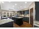 Spacious kitchen boasts dark cabinets, granite counters, stainless appliances, and a large island, flowing into the dining area at 17015 Oxbridge Rd, Monument, CO 80132