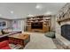 Living room features a stone fireplace, built-in shelves, and large flat screen TV at 17015 Oxbridge Rd, Monument, CO 80132