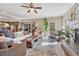 Sunlit living room featuring hardwood floors, a stone fireplace, and a staircase to the second floor at 17015 Oxbridge Rd, Monument, CO 80132