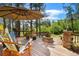 A sunny outdoor deck features stone accents, wood railings, and a firepit for entertaining at 17015 Oxbridge Rd, Monument, CO 80132